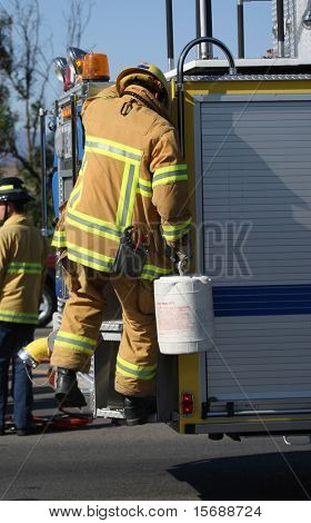 Firefighter climbing on fire truck