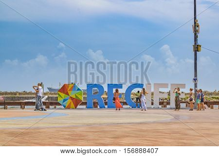 RECIFE, BRAZIL, JANUARY - 2016 - Group of tourist taking photos at Recife letters in Marco Zero square