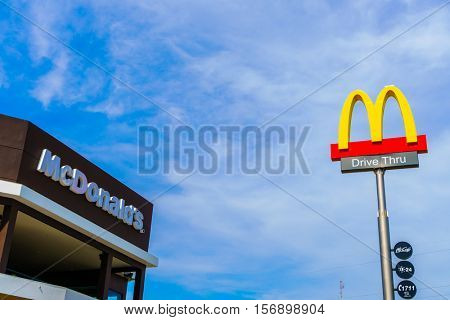 Khonkaen Province, Thailand - December 20, 2015 : McDonalds logo on blue sky McDonald's Corporation is the world's largest chain of hamburger fast food restaurants.