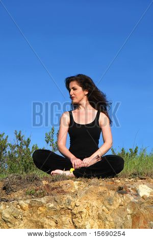 En ung kvinna som mediterar utomhus
