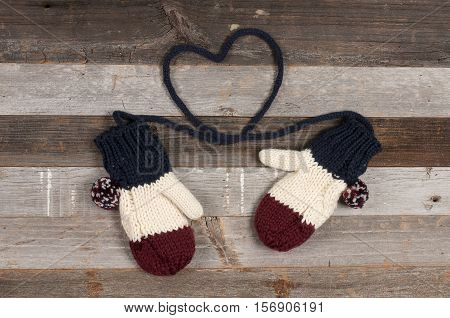 Winter clothing warm knitted mitten on wooden background. Christmas mood