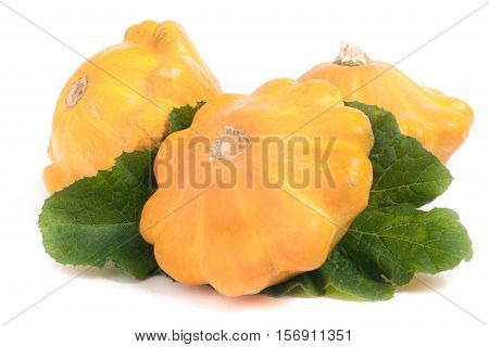 three yellow pattypan squash with leaf isolated on white background.