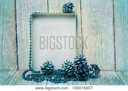 Christmas mokup with empty frameblue bead and cones.New Year.Wooden table