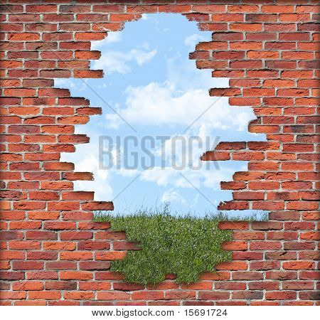 Alte verfallene Mauer vor der einem grasbewachsenen Hügel mit einem bewölkten Himmel