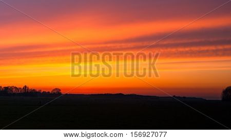 Colorful sunset and intens sky over traditional agricultural landscape in spring