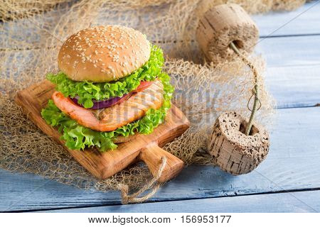 Homemade Fishburger With Salmon On Old Wooden Table