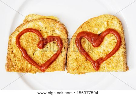 Two fried breads in the egg with hearts of ketchup on white plate. Valentine theme. Creative food. Positive emotions.