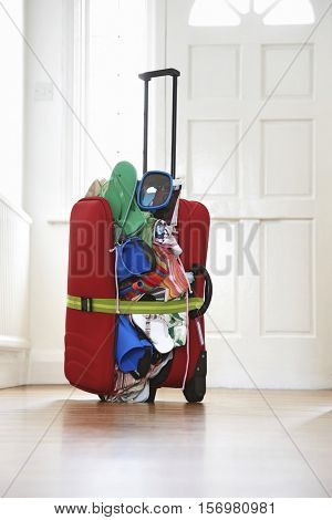 Overstuffed suitcase in hallway