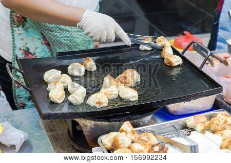 Street food : Crispy fried dumpling in hot pan fry at the night market