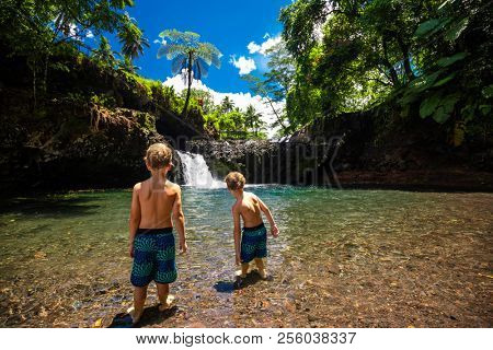 Two boys at Togitogiga falls with swimming hole on Upolu, Samoa Islands