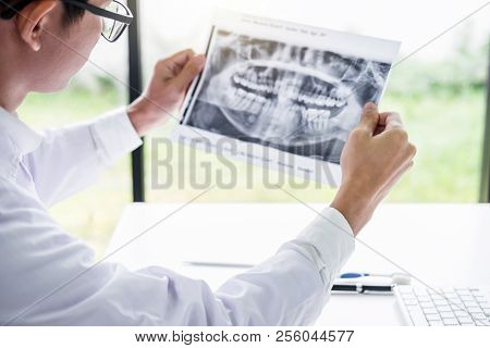 Image Of Male Doctor Or Dentist Holding And Looking At Dental X-ray.