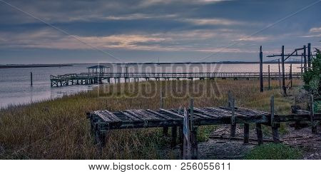 Old Broken And Rotted Wood Piers Over A Marshy Wetland