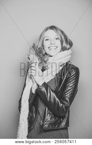 Season And Autumn Holiday. Beauty And Fashion. Girl With Orange Leaves On Blue Background. Woman Wit