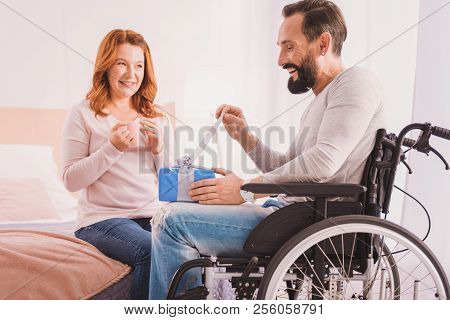Handsome Smiling Disabled Man Opening His Birthday Present