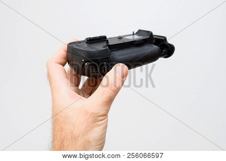 Photographer Hand Holding Against White Background A Battery Camera Grip For His New Camera