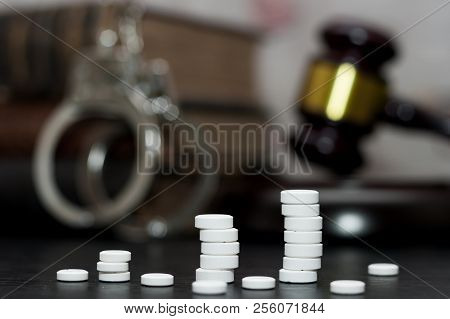 Judge's Gavel With Handcuffs, Drugs On Wooden Table