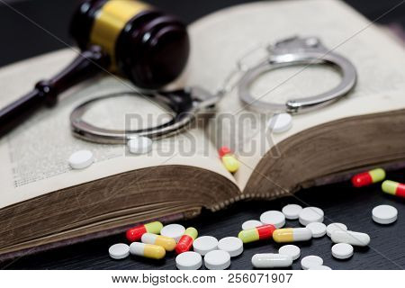 Judge's Gavel With Handcuffs, Drugs On Wooden Table