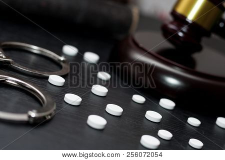 Judge's Gavel With Handcuffs, Drugs On Wooden Table