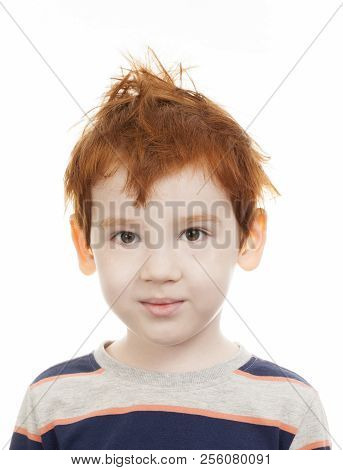 Ruffled Little Boy With Red Hair On A Light Not Isolated Background, Looks At The Camera