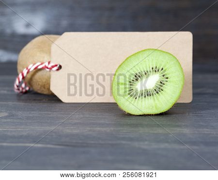 Green Heart And Halves Of Kiwi Fruit With Seeds, Closeup, Near The Second Kiwi Is A Paper Tag For Wr