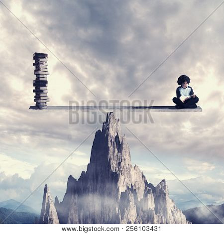 Stundent Reading A Book On Balance Scale Above A Mountain Rock. Knowledge Is Power Concept.