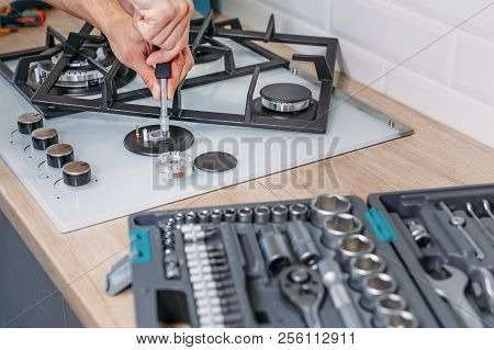 Man Hand Repairs Hotplate Of Gas Panel With Screwdriver