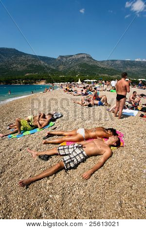 ZAGREB - juli 29: Overfyldte strand af Zlatni Rat på juni 05, 2009 i Bol Kroatien. Bol er en af bussen