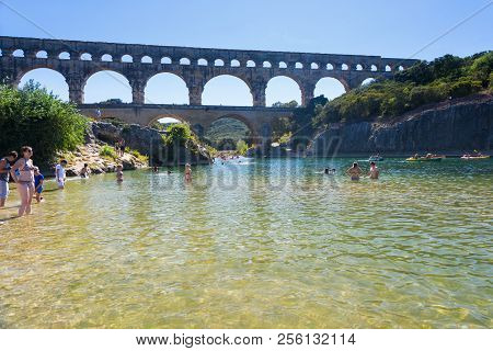 Remoulins,france-august 12, 2016:people Swim And Canoe Near The Pont Du Gard Roman Aqueduct During A