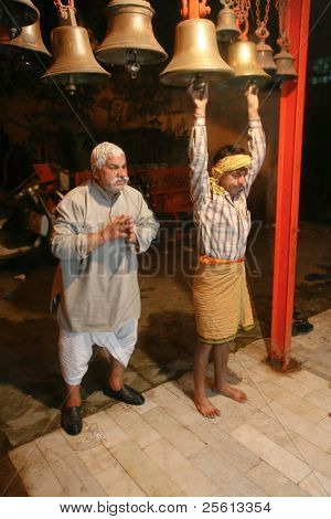 DELHI - 18 januari: Twee mannen beltonen klokken bij de ingang van de tempel om 5 uur op 18 januari 2008 in De