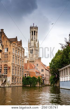 Bruges, Belgium-august 15, 2015-the Belfry Tower And The Medieval Houses At The Canal In Brugge.