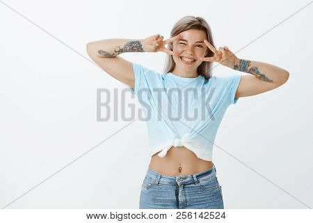 Smile To Camera And Live To Fullest. Happy Positive Woman In Trendy Oufit With Tattooed Arms, Showin