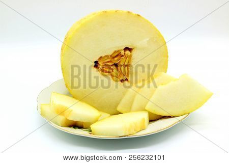Cut Melon On A Plate On A Light Background. Melon Torpedo.