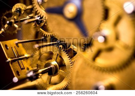 Gears Or Cogs Into A Mechanically Clockwork, Brassy Background