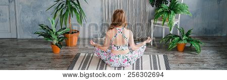 Young Woman Sitting Back In Easy Pose And Meditates In Boho Interrior. Yoga At Home Concept.