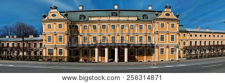 A Large Yellow Building Of The Menshikov Palace With Vases And Crowns On A Green Roof With Windows O