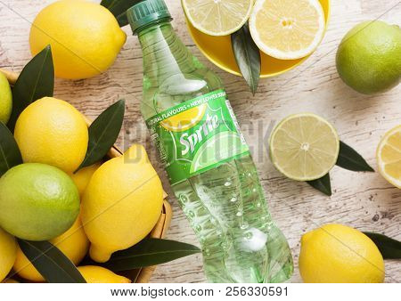 London, Uk - September 03, 2018: Bottle Of Sprite Drink On Wooden Background With Lemons And Limes. 
