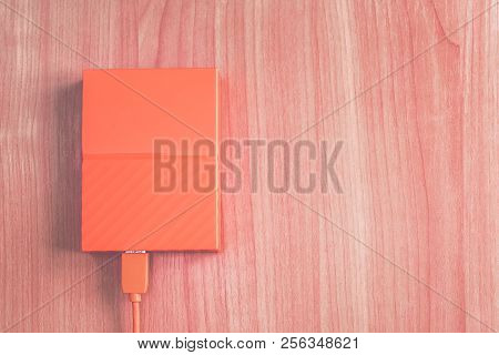 Portable Orange External Hard Drive On The Desk. Copy Space.  External Hard With Laptop On Wooden Ba