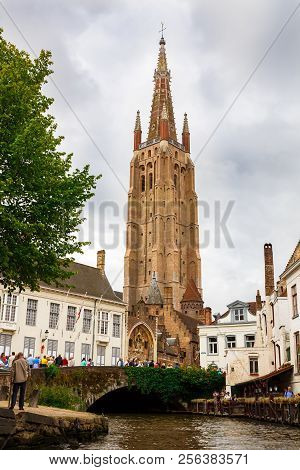 Bruges, Belgium-august 15, 2015-the Church Of Our Lady And The Medieval Houses At The Canal In Brugg