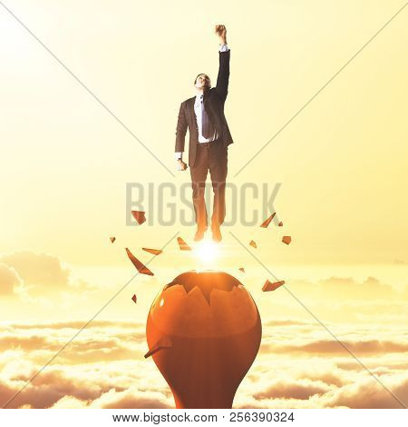 Businessman Launching From Abstract Broken Lamp. Sunset Sky Background. Startup And Freedom Concept