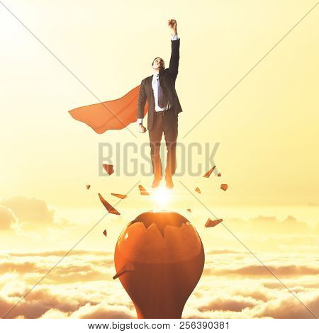 Businessman With Red Hero Cape Launching From Abstract Broken Lamp. Sunset Sky Background. Startup A