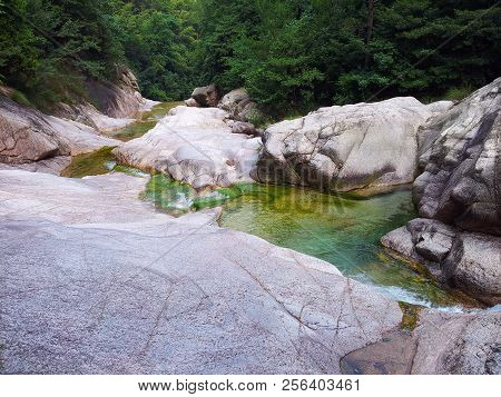Photographed In The Huangshan Scenic Area In China, There Is A Huge Stone On The Green Hillside.