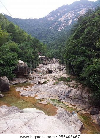 Photographed In The Huangshan Scenic Area In China, There Is A Huge Stone On The Green Hillside.