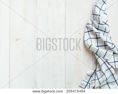 View From Above On White Wooden Table With Linen Kitchen Towel Or Textile Napkin. Blue Tablecloth On