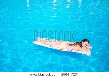 Sleppy Girl Is Lying On Iar Mattress And Chilling. She Gets Some Sun Tan. Young Woman Is In The Midd