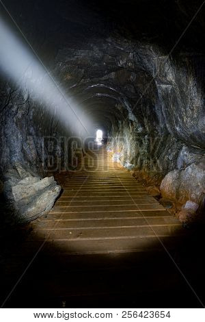 Light From A Flashlight Shining Through A Narrow Cave In The Tow