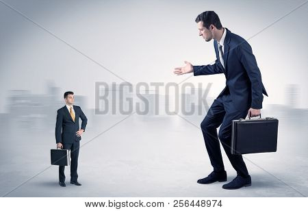 Giant businessman being afraid of small serious executor with suitcase
