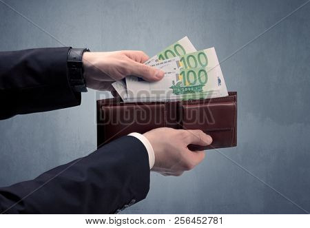 Businessman's hand in suit takes out eruo from his wallet