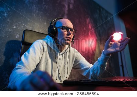 Young Man In Red Headphones Playing Game At Home And Streaming Playthrough Or Walkthrough Video. Cra