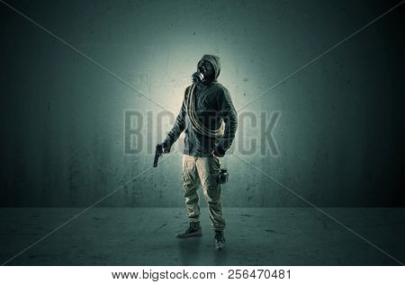 Bad agent in a dark room with arms on his hand and gas mask