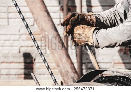 Worker Hands Pulling The Lever Of A Pile Driver (bate-estaca). Construction Worker. Two Hands Holdin